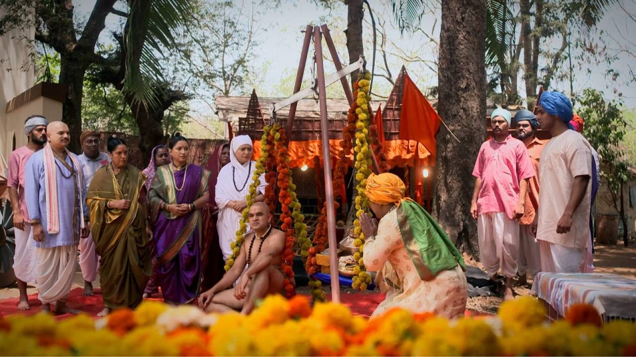 दुसरीकडे, एक अलौकिक तराजू एका बाजूला शांत, स्थिर, तेजस्वी स्वामी बसलेले आणि दुसऱ्या बाजूला मंगलदास एकेक सोन्याच्या भांड्यांनी वजन भरत आहे. पण त्या संपत्तीचा भार स्वामींच्या तेजस्वित्वाशी मुळीच तोंड देऊ शकत नाही. गावकरी अवाक् होऊन हे दृश्य पाहत असतात आणि अखेर त्याची संपत्ती संपते. पण पुण्य संपत नाही.  
